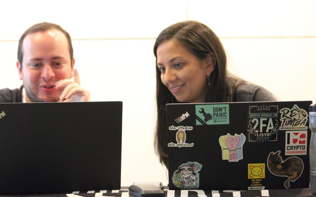 two people looking at a laptop.